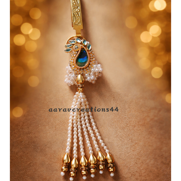 Decorative keychain with pearls and gold accents on a brown background